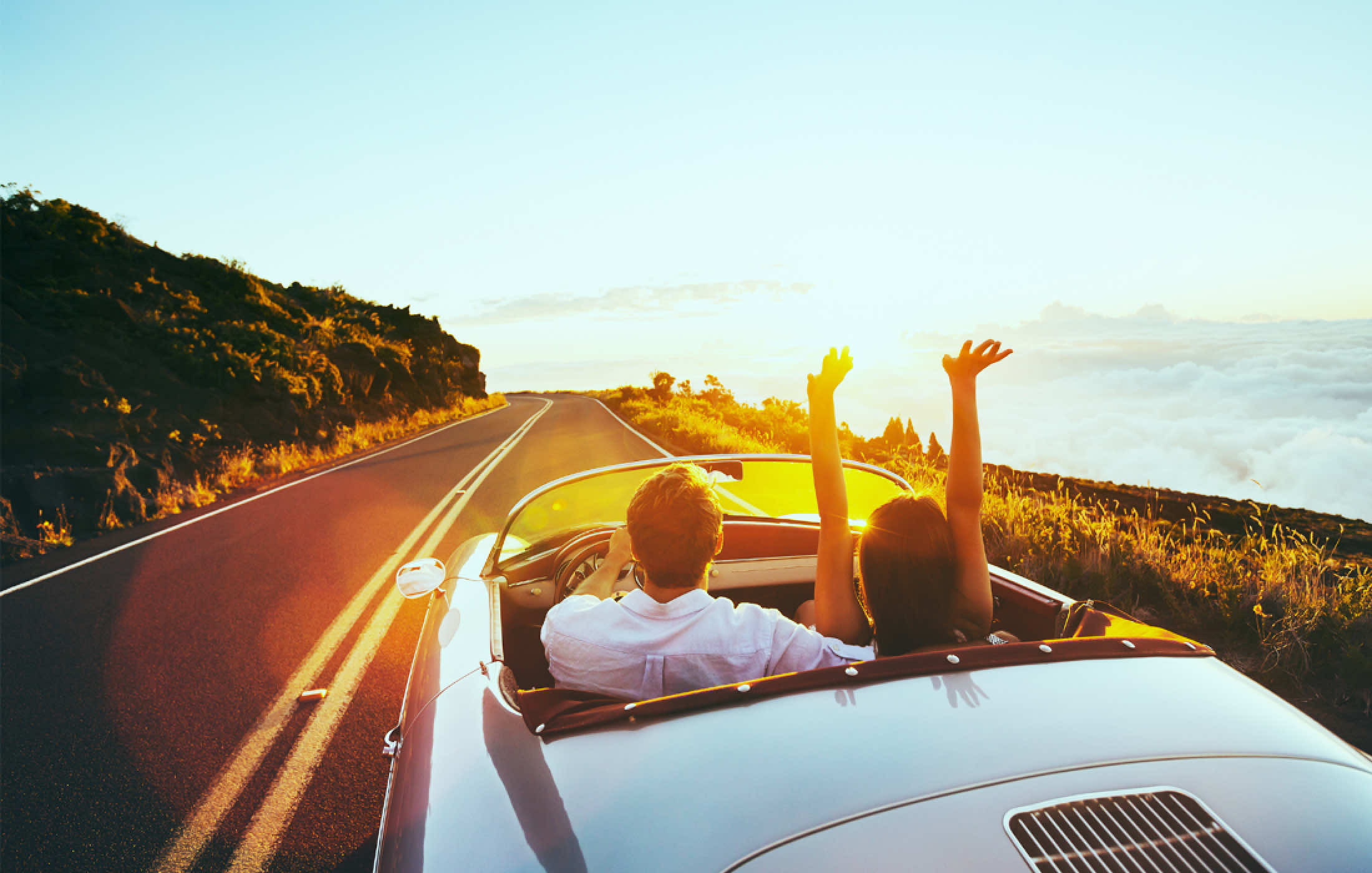 赤色のオープンカーにもたれかかっている女性